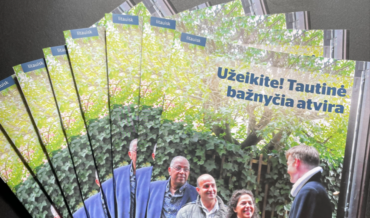 folderen "velkommen ind, folkekirken er åben" på litauisk