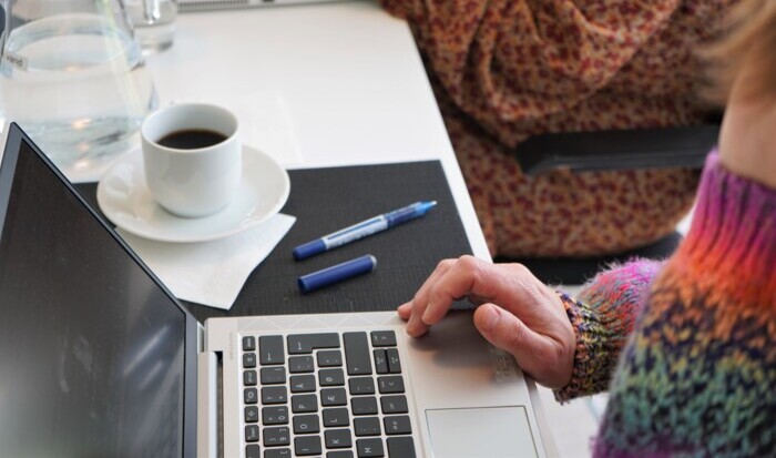  Genrebillede af stiftsrådsmøde, menighedsrådsmøde, referent eller lignende. På billedet ses hænder, computer, kaffekop, kuglepen, etc.