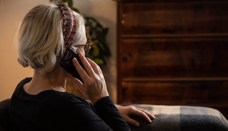 Kvinde taler i mobiltelefon. Kvinden ses bagfra.